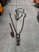 Full layout of three chains with hooks and Gedore wrench on concrete