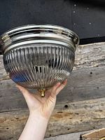 Chrome fixture with ribbed clear glass bowl held in hand