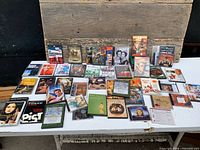 Overall lot view displaying DVDs and some VHS titles on table