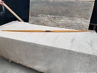 Full view of wooden longbow laid flat