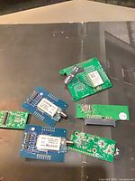 Group view of two blue LumenRadio module boards, three green adapter boards, coax antenna lead