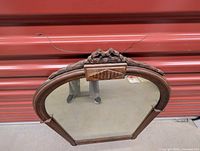 Full view of arched carved wood mirror with hanging wire