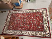Full view of red field Oriental rug with ivory border