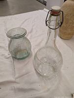 Bottle and vase side by side on table