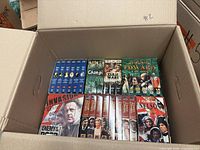 Open carton showing front row of VHS tapes including Changi, Zulu Wars, Edward II, I Remember Nelson, Enemy at the Door, Invasion series