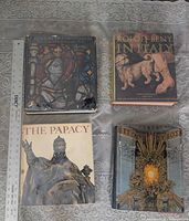 All four books laid out with ruler for scale