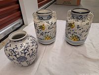 Group shot of one blue-white vase and two matching Italian handled jars