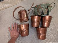 All six items grouped: watering can, verdigris basket, four planters