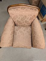 Top view of armchair showing blush damask upholstery and rolled arms