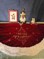 Whole lot showing tree skirt, Santa frame, snowman figure, star shakers and box