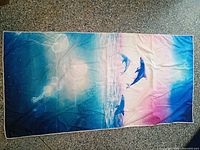 Full view of towel front showing dolphin, jellyfish and sunset design