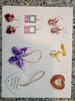 Full lot overview showing earrings, necklace, ornaments and brooch