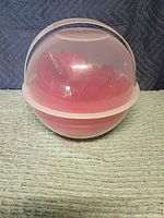 Closed clear carrier showing nested red contents