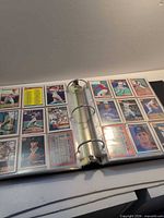Open binder displaying nine-pocket pages filled with Topps baseball cards