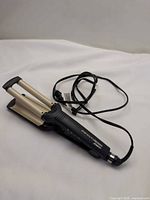Full view of Conair 3-barrel waver with cord coiled