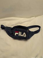 Front view of navy FILA waist bag showing logo pocket and strap