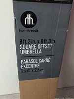 Front of boxed Hometrends square offset umbrella showing brand and dimensions