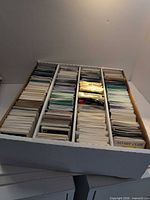 Top view of four-row cardboard box filled with assorted loose cards