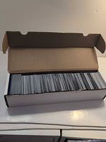 Open cardboard box filled with sleeved cards