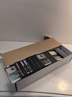 Open long box showing stacked unsleeved Magic cards