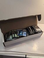 Open white card storage box showing large stack of unsleeved Magic cards