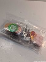 sealed bag showing mixed tokens and dice