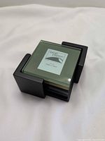 stacked green glass coasters inside black wooden holder showing Sarah Peyton label