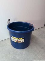 Full view of blue utility tub showing label and both rope handles