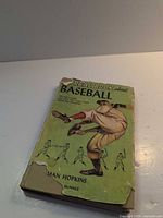 Front view showing green illustrated dust jacket with wear and tears
