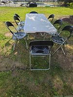 Overall view of table and 8 chairs set up outdoors