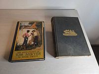 Front covers of both hardcover books showing titles and cover art/decoration