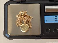Chain and locket on scale showing 9.41 g
