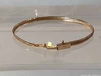 Entire bracelet laid flat showing herringbone pattern and clasp