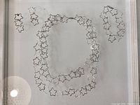 Necklace, bracelet and earrings laid flat on display surface
