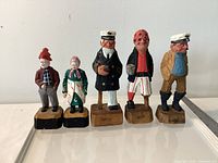 Front view of five wooden nautical figures lined up