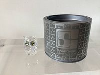 Owl figurine beside branded cylindrical box