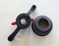 Both adapters facing up showing thread openings and handles with red tabs