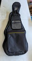 Front view of black padded guitar gig bag with accessory pockets