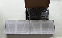 Open carton with one intercom base station in plastic plus two closed accessory boxes
