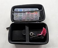 Open carry case showing handheld sewing machine and accessory kit