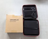 Origbelie external drive in open carrying case with cable and pouch next to branded box