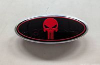 Front view showing black background, red skull graphic, chrome rim