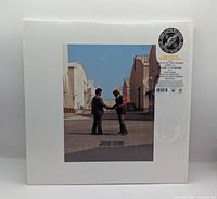 Front of sealed jacket with handshake cover art and hype sticker