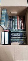 Top view of box showing multiple gilt decorative spines and two slipcased volumes