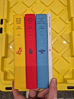 Spines of four cloth-bound books showing titles and author