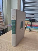 Front spine and cover of beige cloth-bound book with green gilt label