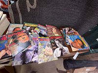 Spread of roughly twenty Autograph Collector magazines on sofa