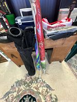 Folded multicolor beach umbrella with pole, black umbrella bag, clamp parts visible