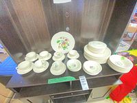 Full set on shelf showing all plates, cups and saucers