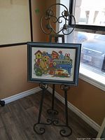 Easel displaying framed cross-stitch